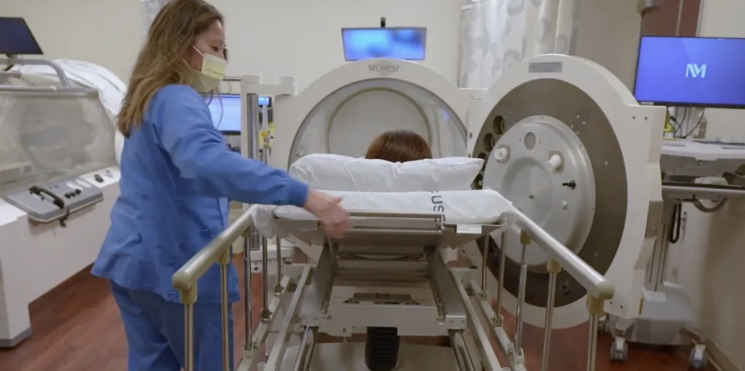 person getting in a hyperbaric oxygen therapy chamber 