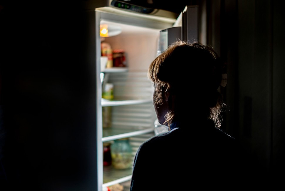 person looking in fridge at night